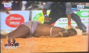 Le lutteur Eumeu Sène, groggy, affalé à plate ventre dans l'arène après les coups violents reçus de son adversaire Modou Lô.