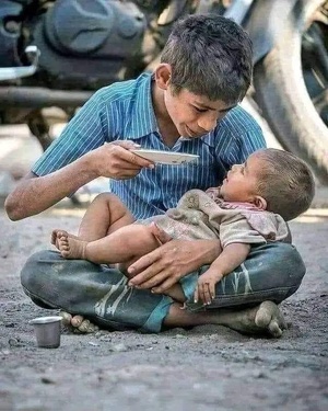 A Gaza, un enfant en train de nourrir un bébé A Gaza, un enfant en train de nourrir un bébé