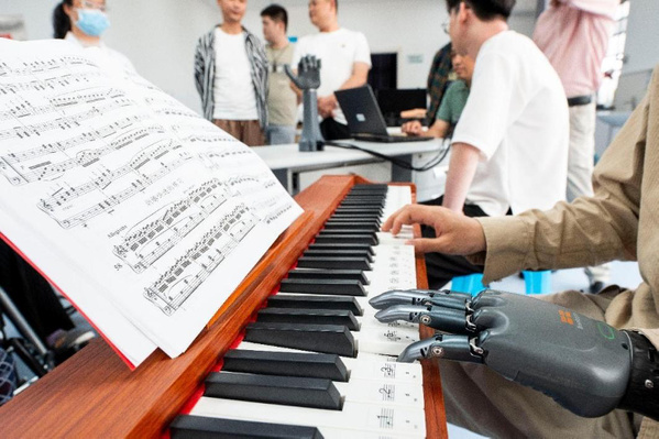 À l'hôpital de réadaptation de Xuancheng, dans la province de l'Anhui (est de la Chine), une personne handicapée joue un morceau de piano avec une main bionique intelligente. (Photo / Li Xiaohong)