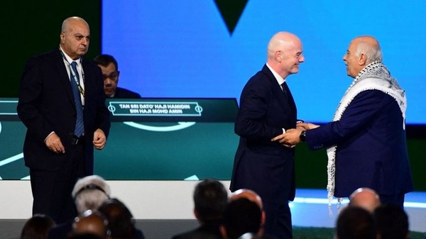 Le président de la Fifa Gianni Infantino entre Jibril Rajoub, président de la Federation palestinienne de football (D) et Basim Sheikh Sulimane (G), dirigeant du football de l'entité sioniste, le 30 avril 2026 à Vancouver (Canada). (Photo AFP)